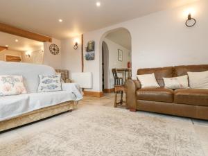 1 dormitorio con 1 cama y 1 sofá en Woodbine Cottage, en Falmouth