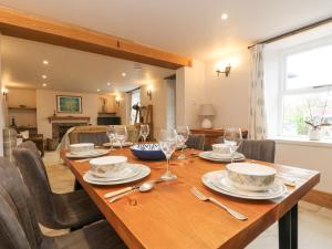 a dining room with a wooden table with wine glasses at Woodbine Cottage in Falmouth
