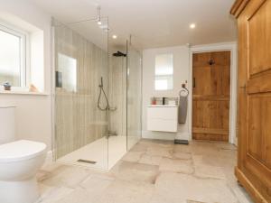 a bathroom with a glass shower and a toilet at Woodbine Cottage in Falmouth +43 photos