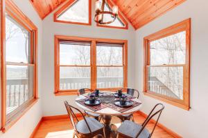 a dining room with a table and chairs and windows at Scenic Murphy Cabin about 16 Mi to Blue Ridge in Murphy