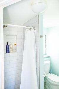 a bathroom with a shower curtain and a toilet at Sun-Drenched 1BR Apt - 5min walk to Beach in Clearwater Beach