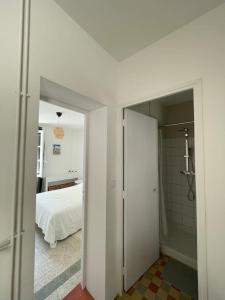 a white room with a bed and a bathroom at Maison avec patio proche place des Carmes in Avignon