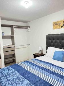 1 dormitorio con 1 cama con manta azul y blanca en Beautifull 2 bedroom, 2 full washroom en Guatemala