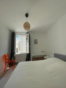 ein Schlafzimmer mit einem weißen Bett und einem Fenster in der Unterkunft Maison avec patio proche place des Carmes in Avignon