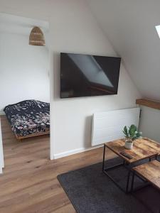 ein Wohnzimmer mit einem TV an der Wand in der Unterkunft Appartement 2 chambres in Lesneven