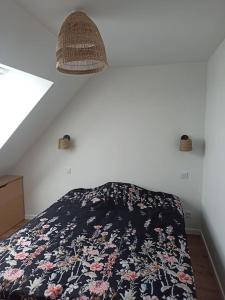 ein Schlafzimmer mit einem Bett mit einer Blumendecke in der Unterkunft Appartement 2 chambres in Lesneven