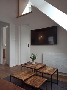 ein Wohnzimmer mit 2 Holztischen und einem TV in der Unterkunft Appartement 2 chambres in Lesneven