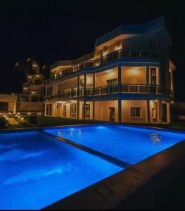 a large swimming pool in front of a house at night at ST Beach Villa in Kibweni