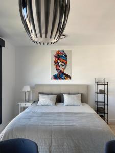 ein Schlafzimmer mit einem großen Bett und einem Gemälde an der Wand in der Unterkunft Urban Sky Views over Malaga in Málaga