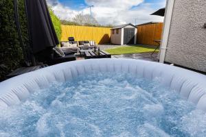 uma grande piscina de água num quintal em Steel Town Lodge - Comfy Home in Port Talbot with Hot Tub, Sky Sports & Dart Board em Port Talbot