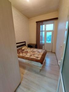 um quarto com uma cama e uma grande janela em Модерн в историческом сердце em Yerevan