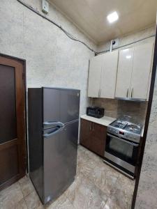 uma cozinha com um frigorífico de aço inoxidável e armários em Модерн в историческом сердце em Yerevan