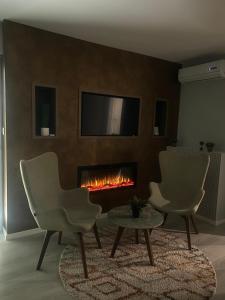 a living room with two chairs and a fireplace at Diamond apartments in Sarajevo