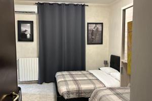 1 dormitorio con 2 camas y cortinas azules en Central Station Studio Flat, en Milán