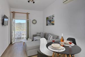 sala de estar con mesa y sofá en tsoukalaria studios, en Skopelos Town