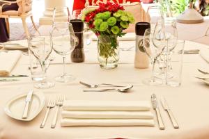 una mesa con vasos y un jarrón de flores y cubiertos en Quinta Jacintina - My Secret Garden Hotel en Vale do Lobo