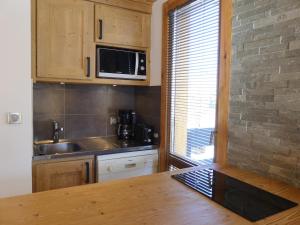 uma cozinha com um lavatório e um micro-ondas em Appartement Méribel, 2 pièces, 4 personnes - FR-1-182-58 em Méribel