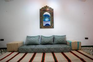 - un canapé dans le salon avec une photo sur le mur dans l'établissement Dar Ribati, à Sale
