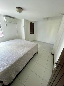 um quarto com uma cama num quarto branco em Numar_casa em Cabedelo