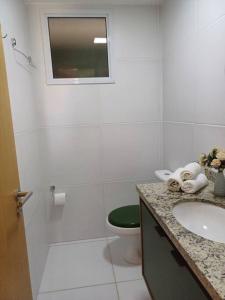 La salle de bains blanche est pourvue de toilettes et d'un lavabo. dans l'établissement Village Baixio, à Baixio