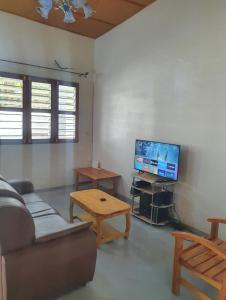 uma sala de estar com um sofá e uma televisão em Delalie Hotel em Palimé