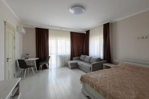 ein Hotelzimmer mit einem Bett, einer Couch und einem Tisch in der Unterkunft Sagora Hotel in Czernowitz + 45 Fotos