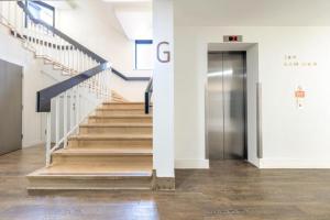 a hallway with stairs and a elevator in a building at Van Gogh Apartment, Bedford - Fast Wifi, Gym & FREE Parking in Bedford