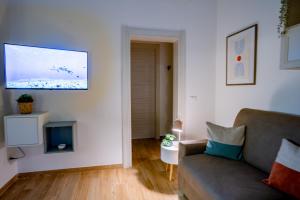 een woonkamer met een bank en een tv bij Dante95 in Polignano a Mare