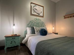 Hotel Casa Aure في سانتياغو: غرفة نوم مع سرير كبير مع اللوح الأمامي الأزرق