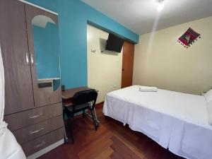 a bedroom with a bed and a desk with a mirror at MISKI PUÑUY - Dulces sueños HOSPEDAJE in Cusco