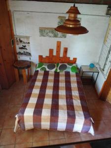 um quarto com uma cama com uma mesa e um candeeiro em Raíces del Bolsón em El Bolsón