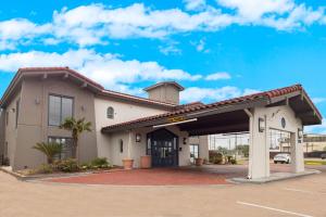 a building with a garage with a parking lot at Motel 6-Beaumont, TX in Beaumont