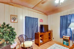 a living room with a tv on a wooden dresser at Tumbling Shoals Home with Private Yard and Grill! in Heber Springs