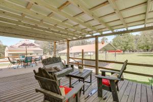 a porch with chairs and a couch and a table at Tumbling Shoals Home with Private Yard and Grill! in Heber Springs