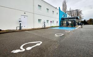 Un estacionamiento vacío con un edificio y una piscina. en Kyriad Direct Moulins Sud - Yzeure, en Moulins
