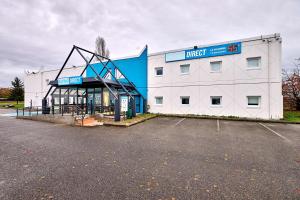 a large white building with a parking lot at Kyriad Direct Moulins Sud - Yzeure in Yzeure