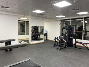 a gym with tread machines and mirrors in a room at Best Western Premier M Four Hotel in Dubai