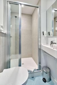 W łazience znajduje się prysznic, toaleta i umywalka. w obiekcie Kyriad Direct Moulins Sud - Yzeure w mieście Yzeure