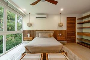a bedroom with a bed and a large window at Hermosa Palms, Casa Lorenzo Beach Front Club House in Playa Hermosa