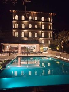 a hotel with a swimming pool in front of a building at Hotel Ristorante Al Caminetto WorldHotels Crafted Adults Only in Torri del Benaco