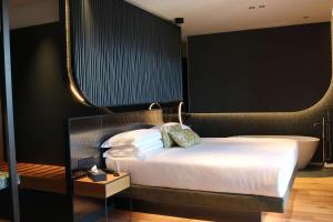 una camera con letto e vasca da bagno di Hotel Al Caminetto WorldHotels Crafted Adults Only a Torri del Benaco