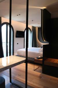 ein Schlafzimmer mit einem Bett und einem Tisch darin in der Unterkunft Hotel Al Caminetto WorldHotels Crafted Adults Only in Torri del Benaco