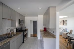 a kitchen with white cabinets and a living room at 3Bed City Ranch near DTR in Raleigh