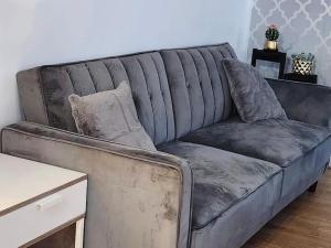 a grey couch in a living room with a table at Spacious 2 bedroom 2 Bathroom Flat in Hatfield near Hertfordshire University with Private Car Park Sleeps 5-6 in Hatfield