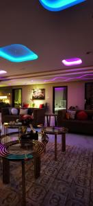 a living room with couches and tables and blue lights at منتجع سمايل in Al Qurayyat