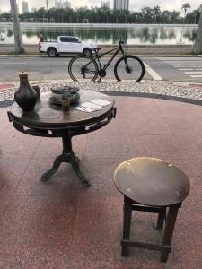 una mesa con un jarrón y un taburete y una bicicleta en Vegaspub1600 en Campina Grande