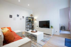 ein Wohnzimmer mit einem Sofa und einem TV in der Unterkunft Warm 2 bedrooms apartement - c38 in Paris