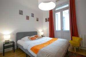 een slaapkamer met een groot bed en een gele stoel bij Warm 2 bedrooms apartement - c38 in Parijs