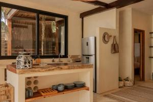 a kitchen with a sink and a refrigerator at Aldea Canzul Tulum in Tulum