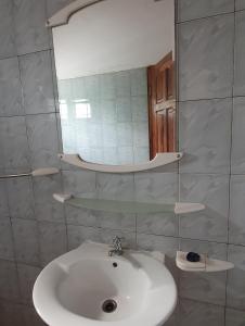 a bathroom with a sink and a mirror at Delalie Hotel in Palimé